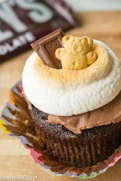 there is a cupcake with chocolate frosting and a piece of candy on top