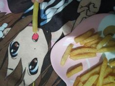 a pink plate topped with french fries next to a cartoon character