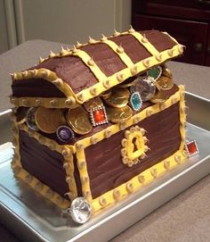 a cake made to look like a chest with gold coins on the top and sides