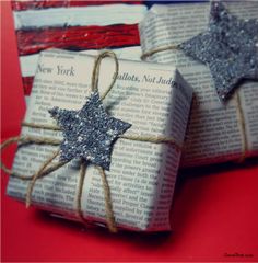 two wrapped presents are sitting on top of an american flag tablecloth and tied with twine