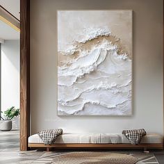 a large white painting hanging on the wall above a couch