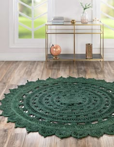 a green rug on the floor in front of a window