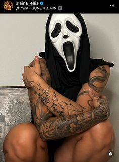 a person with tattoos and a mask on