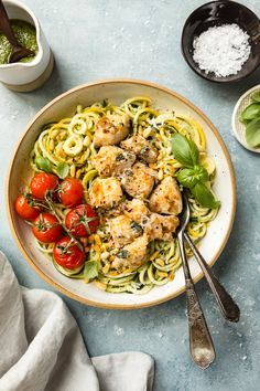 a plate of pasta with chicken and tomatoes