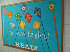 a bulletin board that says soar to new heights read with colorful flags on it