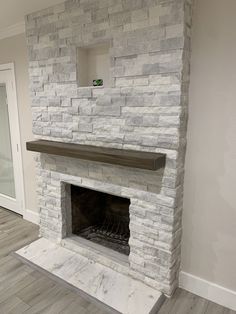 an empty room with a stone fireplace in it