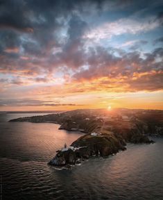 the sun is setting over an island in the ocean