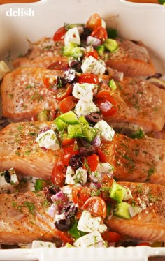 salmon with tomatoes, cucumber, olives and feta cheese in a casserole dish