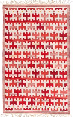 a red and white rug with fringes on the bottom, in an old style pattern