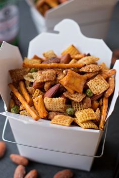 a white box filled with cheetos and nuts on top of a black table