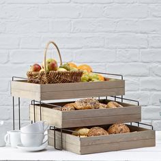 three wooden trays filled with pastries and fruit on top of a white table