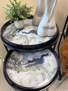 two tiered trays with vases and plants on them sitting next to each other