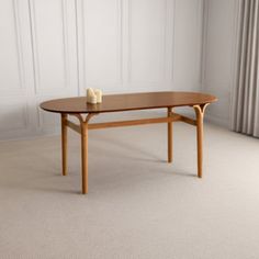 a wooden table with two candles on it in front of a white wall and drapes