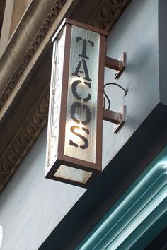 a sign on the side of a building that says taco's