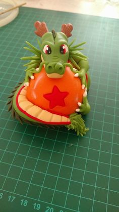 a green toy sitting on top of a cutting board