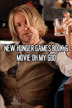 a man sitting in a chair holding a glass with the caption new hunger games book & movie oh my god