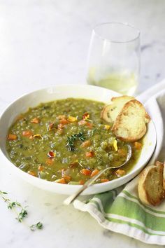 a bowl of soup with bread on the side