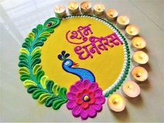 a colorful rangolite with candles around it and the words happy diwali