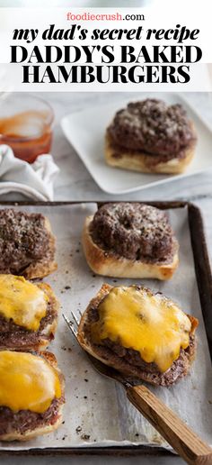 some hamburgers are sitting on a baking sheet