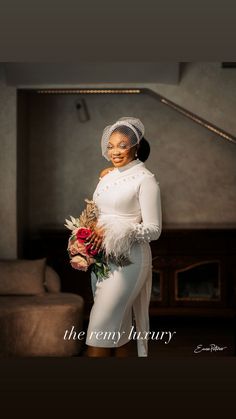 a woman in white is holding flowers and posing for the camera with her hands on her hips