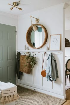 a room with a mirror, coat rack and other items on the wall in it