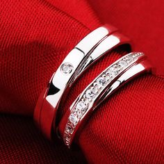 two wedding rings on top of each other, with diamonds in the middle and bottom