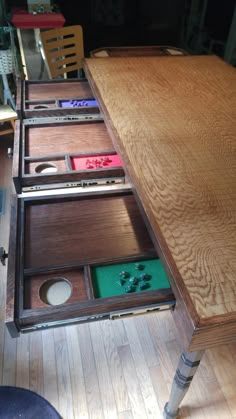 a wooden table with drawers that are open