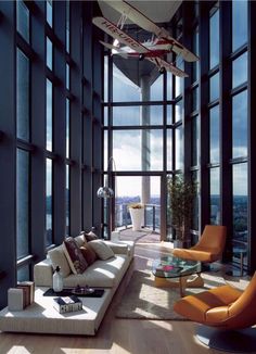 a living room filled with lots of windows and furniture next to a tall window sill