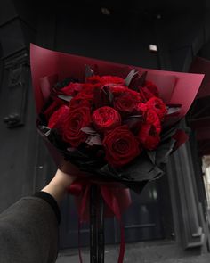 a person holding a bouquet of red roses