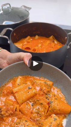 a person holding a pan filled with food on top of a stove