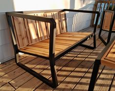 a wooden bench sitting on top of a wooden floor next to a white building with windows