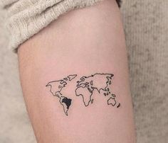 a small world map tattoo on the arm