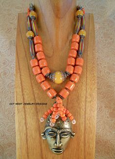 Check out this gorgeous, chunky Tribal style necklace!! I put it together using some handcrafted, coral orange barrel shaped beads from Africa, orange glass pony beads from the Ivory Coast, some elongated red, yellow, black & white African chevron beads and graduated sizes of golden yellow jade rounds.  The focal point of this eye catching piece is the 2-1/8" x 3-1/2" hand crafted brass pendant depicting an African mask. More orange Ivory Coast pony beads adorn the mask. Lots of nice copper spac Luxury Orange Spiritual Beaded Necklaces, Beaded Jewelry Necklaces, African Beads, Pony Beads, Brass Pendant, Multi Strand Necklace, Strand Necklace, Bead Caps, Multi Strand