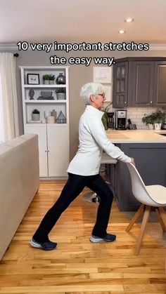 an older woman is using a chair to move around the kitchen island in her home