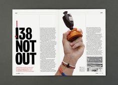 an open magazine with a hand holding a piece of wood and the words 138 not out on it