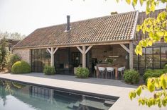 a house with a pool in front of it and some plants on the other side