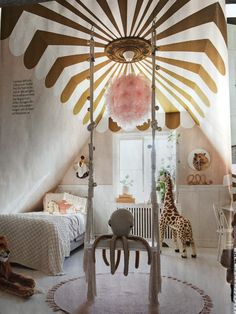 a child's bedroom decorated in pink and gold with a giraffe on the wall