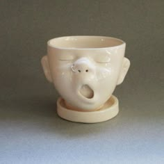 a white cup with an elephant's head sticking out of it