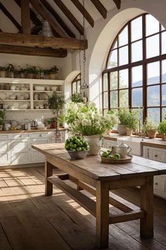 a kitchen filled with lots of windows next to a wooden table topped with green vegetables