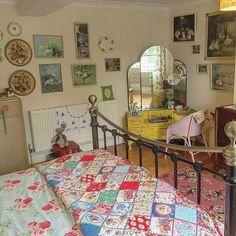 a bed room with a neatly made bed and lots of pictures on the wall