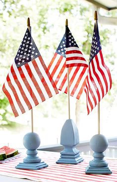 three american flags on top of each other in front of a table with plates and utensils