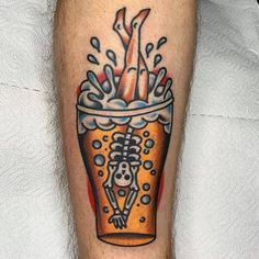 a tattoo on the leg of a man with a skeleton in a beer glass and water splashing out of it