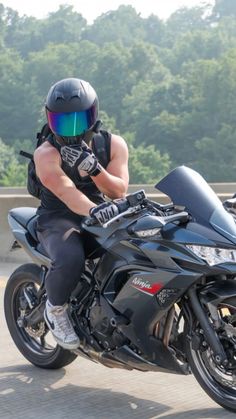 a man riding on the back of a black motorcycle