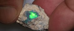 a person holding a rock with a green light in it