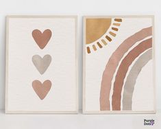 two cards with hearts and a rainbow are on the white wall next to each other