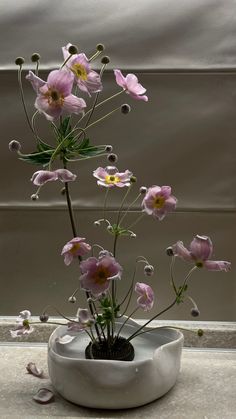 a white vase with pink flowers in it