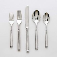 an assortment of silverware including forks, knives and spoons on a white surface