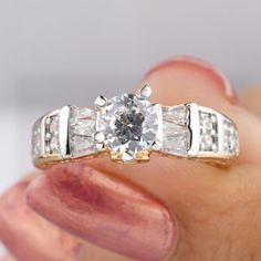 a person holding a ring in their hand with a diamond on the top and sides