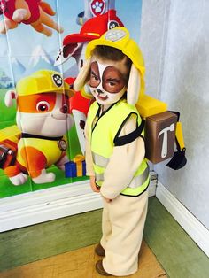 a young boy dressed up as a fireman with his face painted like a dog