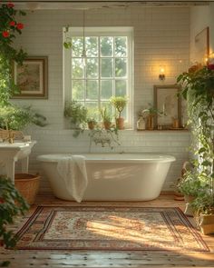 a white bath tub sitting under a window next to a rug and potted plants